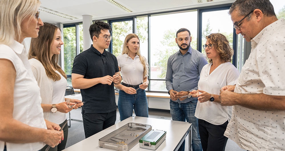 Eine Gruppe steht um einen Tisch mit aufbereiteten Medizinprodukten herum
