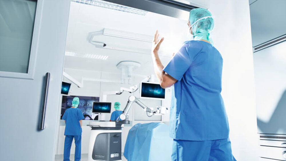 Ein Chirurg betritt den OP, um eine Operation mit dem Aesculap Aeos® durchzuführen. 