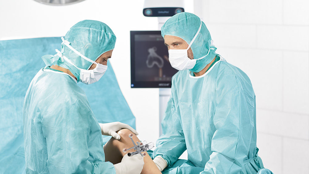 Zwei Chirurg*innen mit OrthoPilot® Elite Navigationsunterstützung im OP