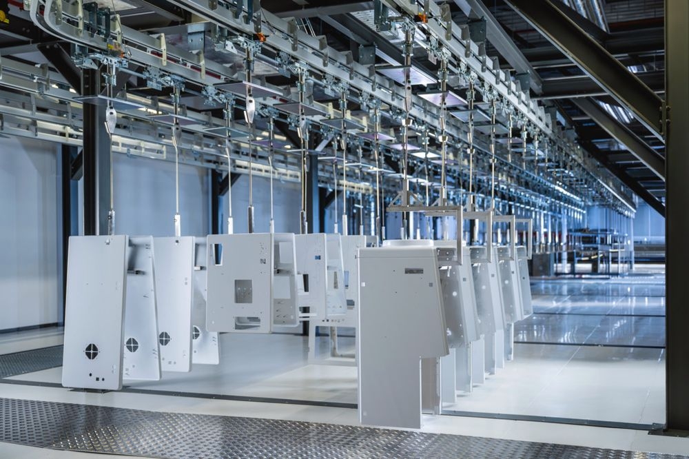 Automatisierte Produktionslinie mit aufgehängten Bauteilen in einer industriellen Fertigungsumgebung von B. Braun.