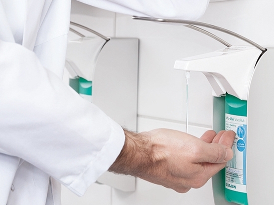 Männliche medizinische Fachkraft, die Handhygienespender verwendet