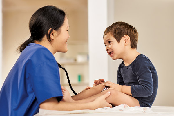 Kinderarzt spricht mit Patientenjunge